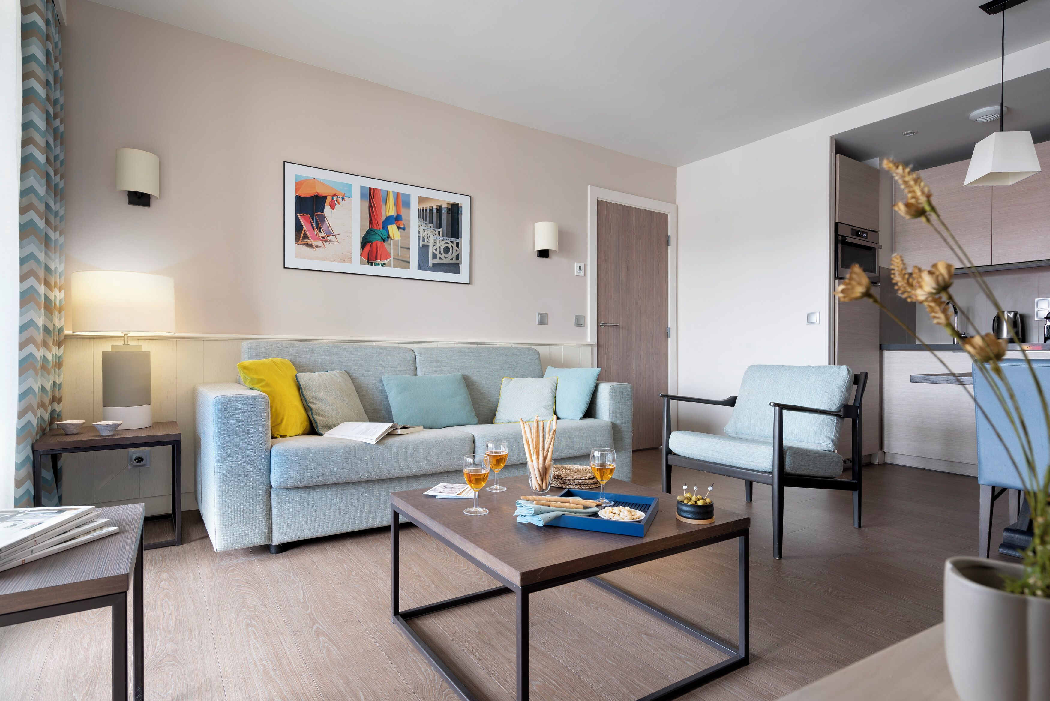 A modern living room with a sofa, coffee table, and a dining area.
