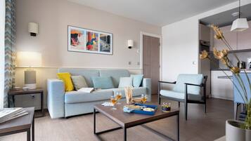 A modern living room with a sofa, coffee table, and a dining area.