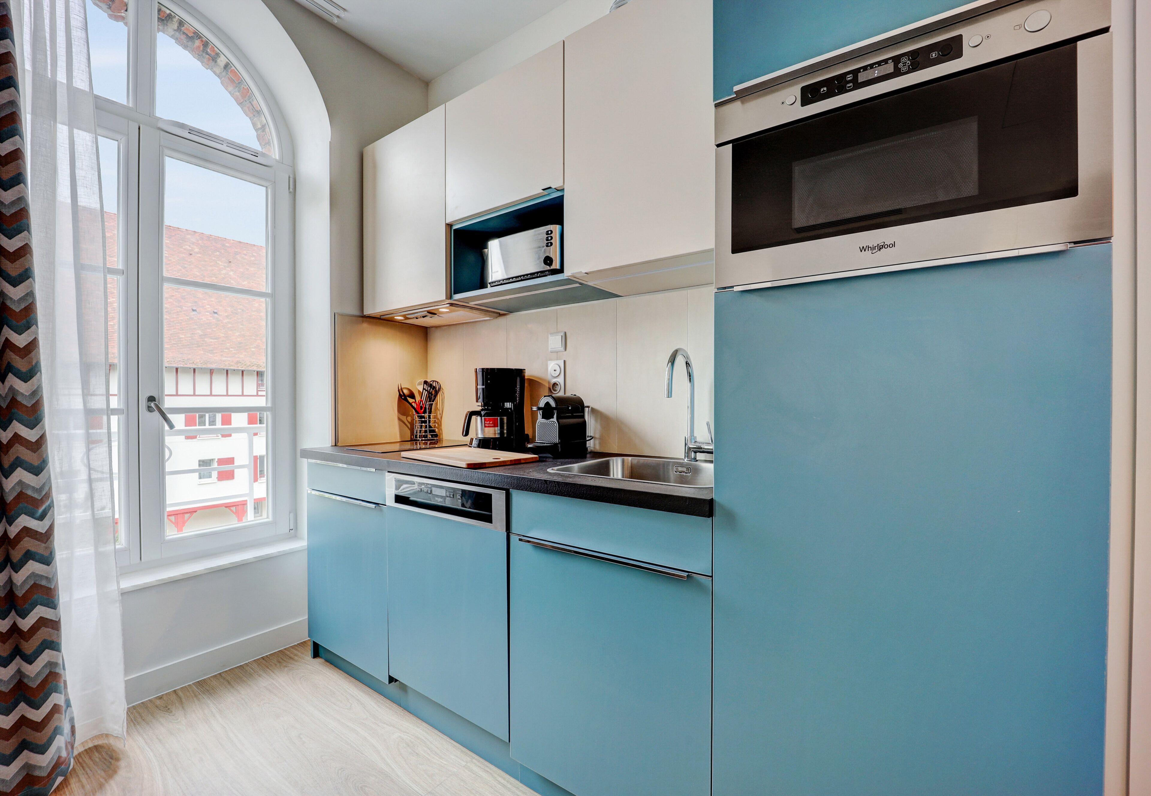 A modern kitchen with a dishwasher, a microwave, and a coffee maker.