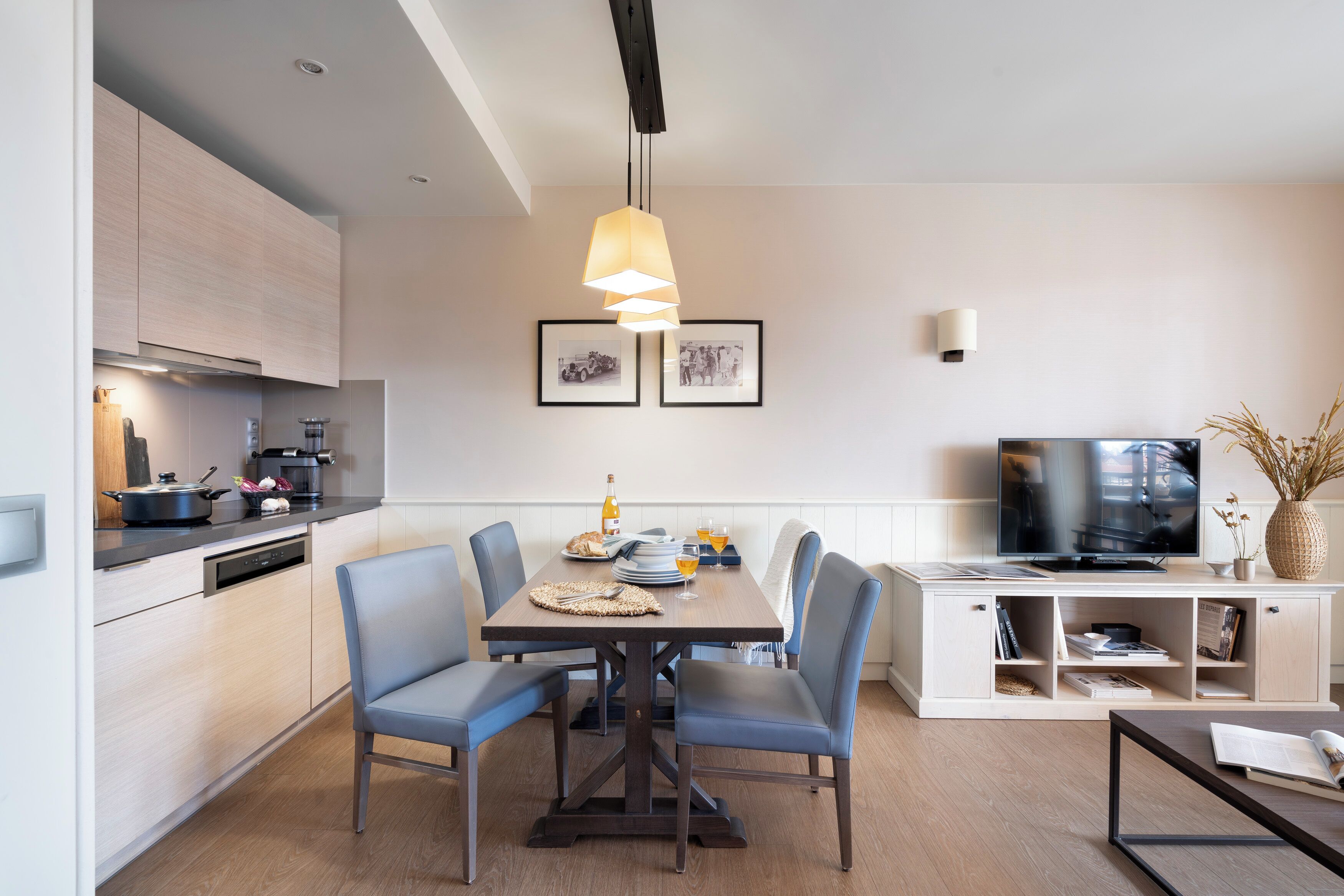 Una cocina moderna con comedor, televisor y estantería.