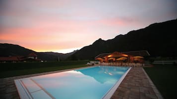 Una piscina al aire libre, sillones reclinables de piscina