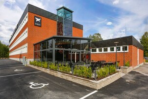 A building with a 'FIRST' logo, a covered outdoor seating area, and a parking lot with handicapped spaces.