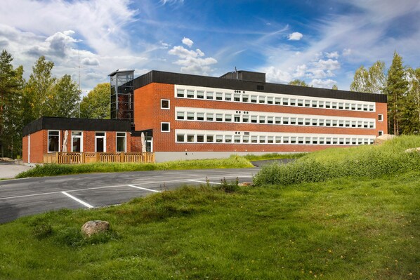 A multi-story building with a brick facade, large windows, and a flat roof.