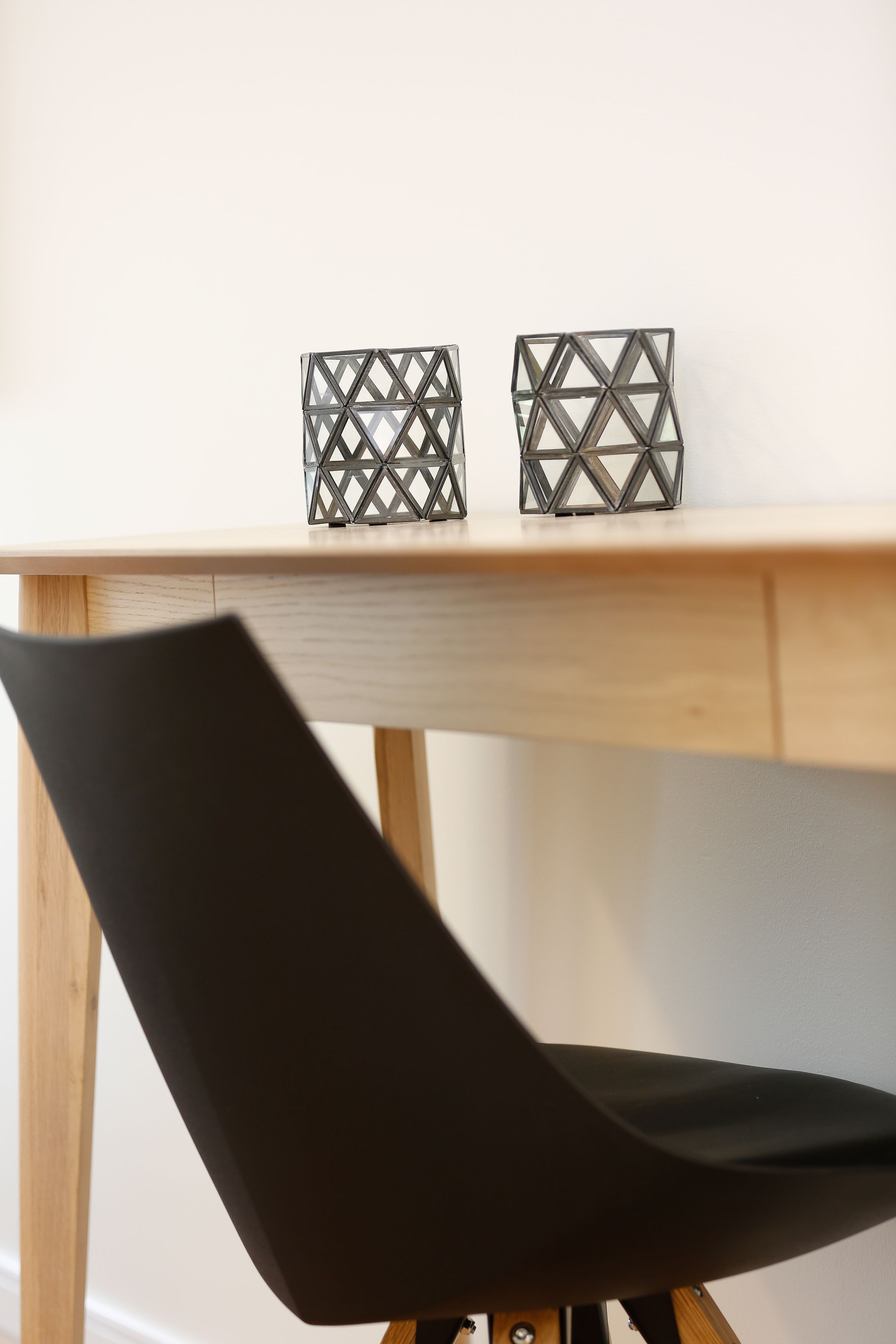 Una mesa de madera con dos candelabros de diseño geométrico.