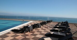 Una piscina al aire libre de temporada, sombrillas