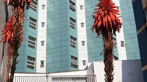 A high-rise building with the sign "Costa Pacifico" at the top.