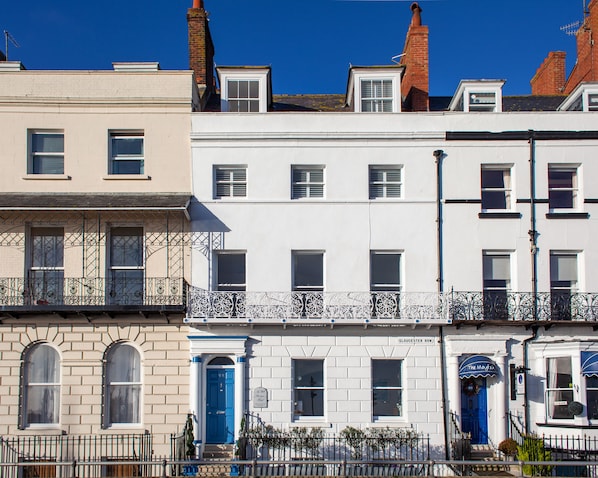 A row of townhouses with distinct architectural styles, including a blue door and a sign indicating 'Gloucester Row'. - No 98 Boutique Hotel (Weymouth)