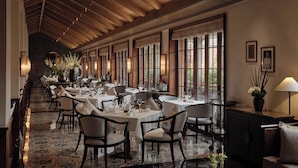 A long, elegant dining area with high ceilings and large windows, featuring multiple tables and chairs arranged for dining. - Capella Shanghai, Jian Ye Li (Shanghai)