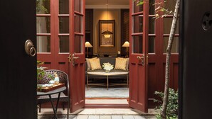 A traditional Japanese-style room with tatami flooring, a low table with a tray of items, and a sofa with cushions. - Capella Shanghai, Jian Ye Li (Shanghai)