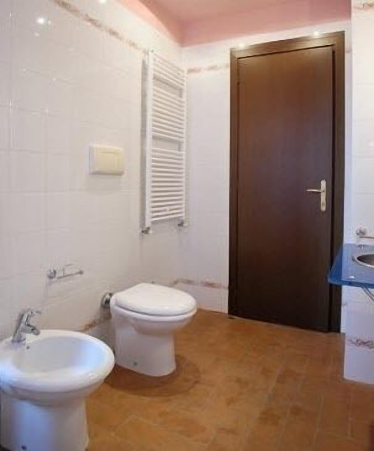 A small bathroom with a toilet, bidet, and sink.