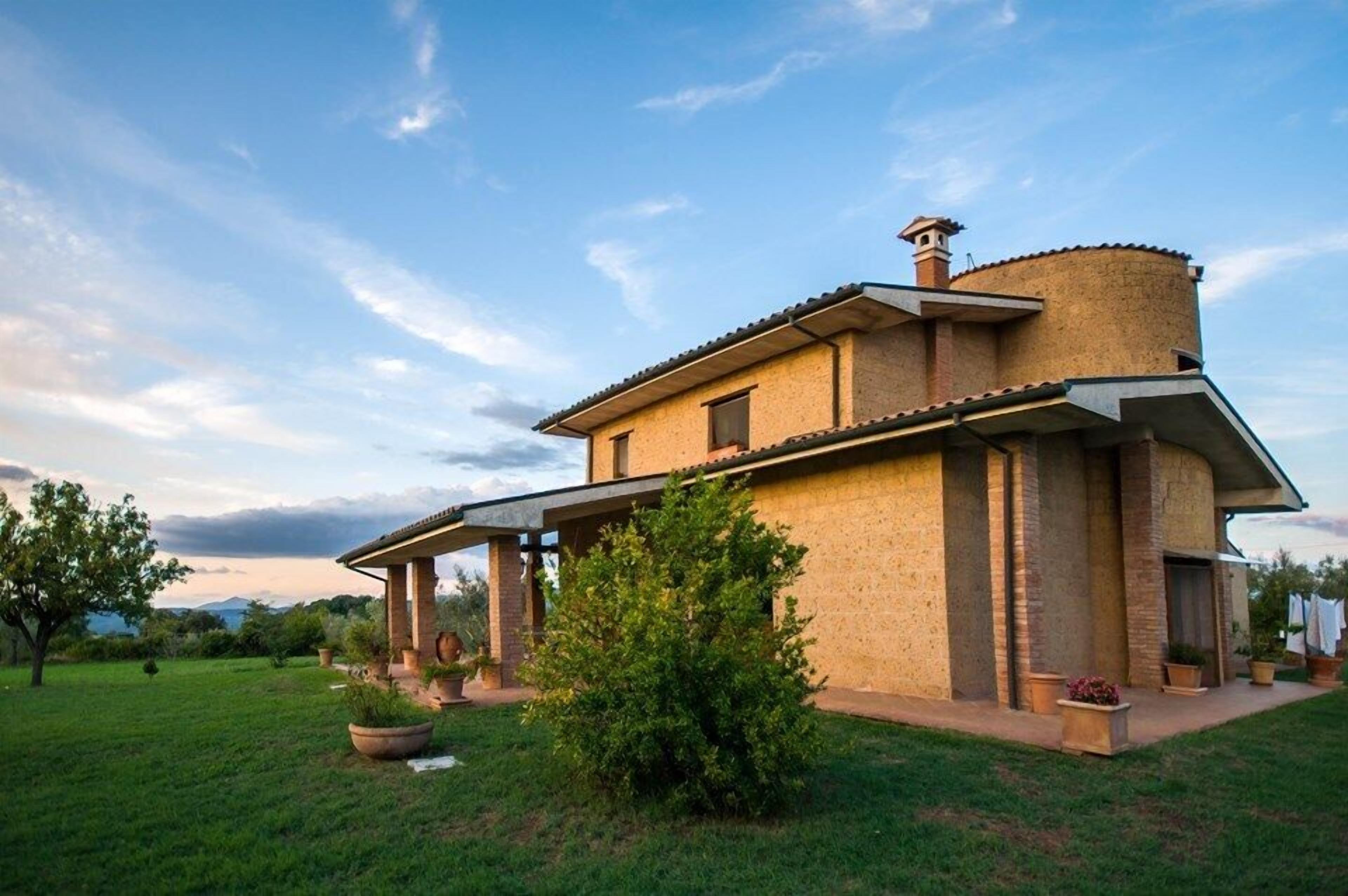 A two-story house with a covered patio and a brick exterior.