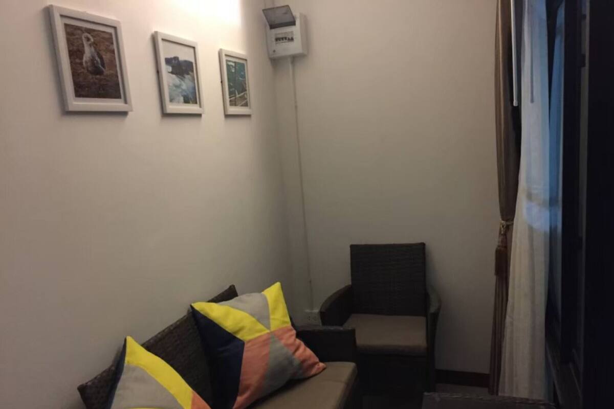 Une pièce comprenant un canapé, un fauteuil et trois tableaux encadrés accrochés au mur.