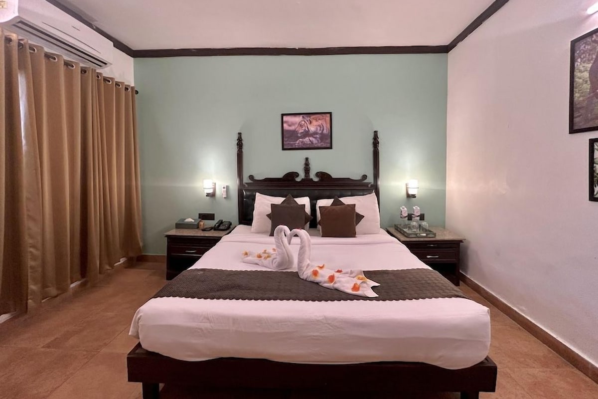 Habitación de hotel con una cama grande, dos mesitas de noche, un cabecero y una obra de arte colgada en la pared.