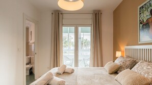 Ein Hotelzimmer mit Bett, einem Vorhangfenster, einer Heizung und einem Bild an der Wand.