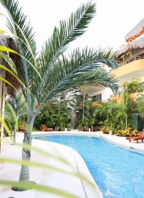 Alberca al aire libre y camastros 