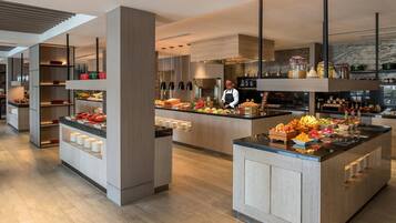 A modern kitchen with a central island, built-in shelves, and a variety of food items.