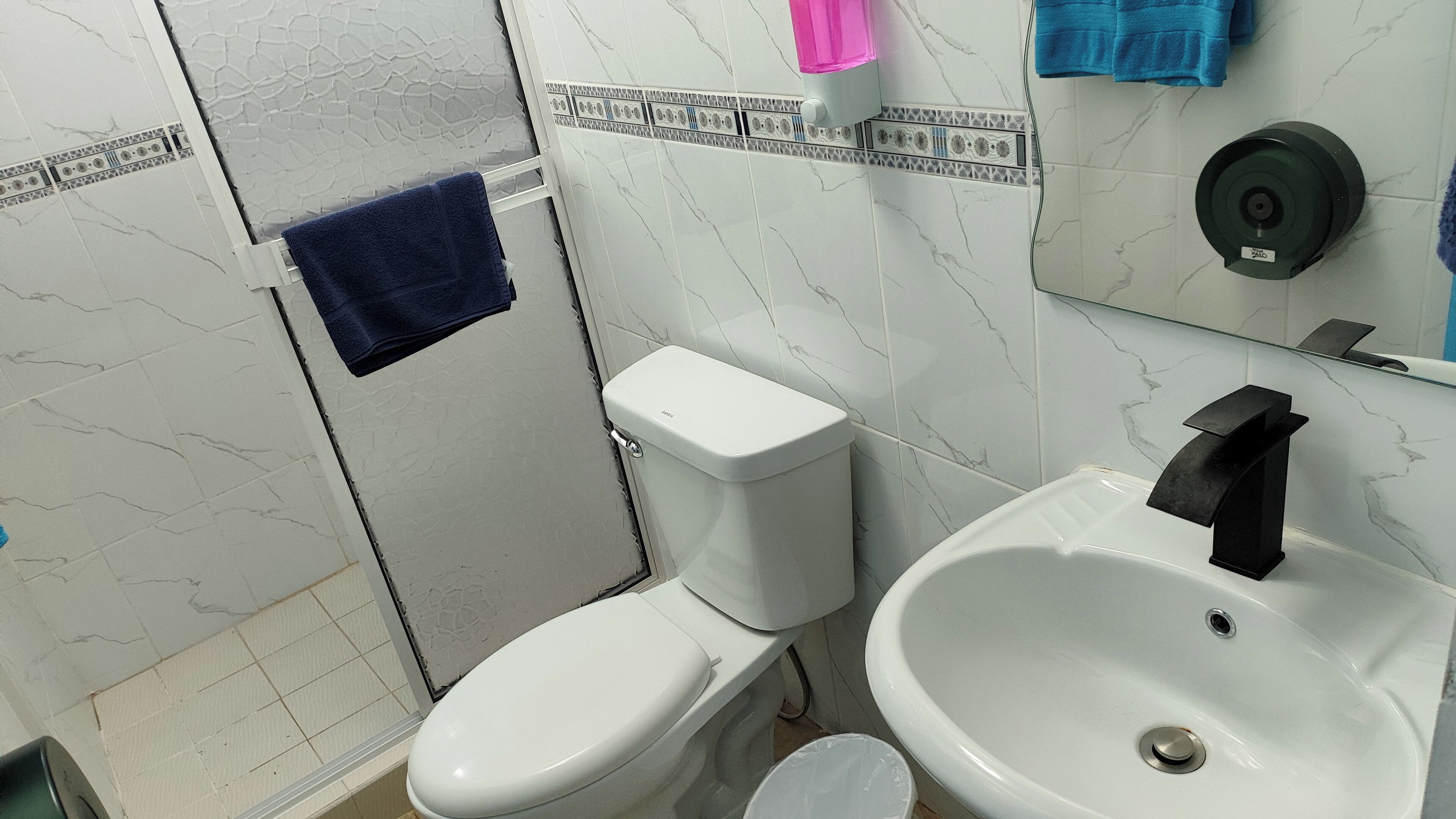 A bathroom with a toilet, sink, and a towel rack.