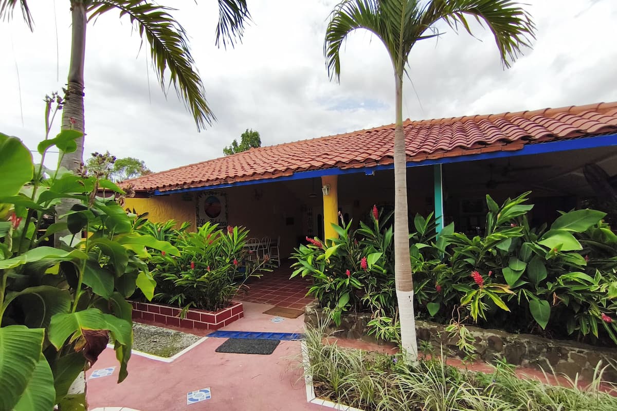 Un bâtiment doté d’un toit recouvert de tuiles rouges et d’un patio abrité.