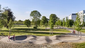 A park with a skate park, walking paths, and trees. - Ibis Budget Muenchen City Olympiapark (Munich)