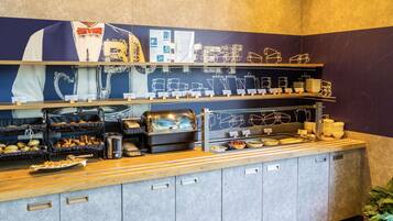A breakfast buffet with various food items and coffee machines.