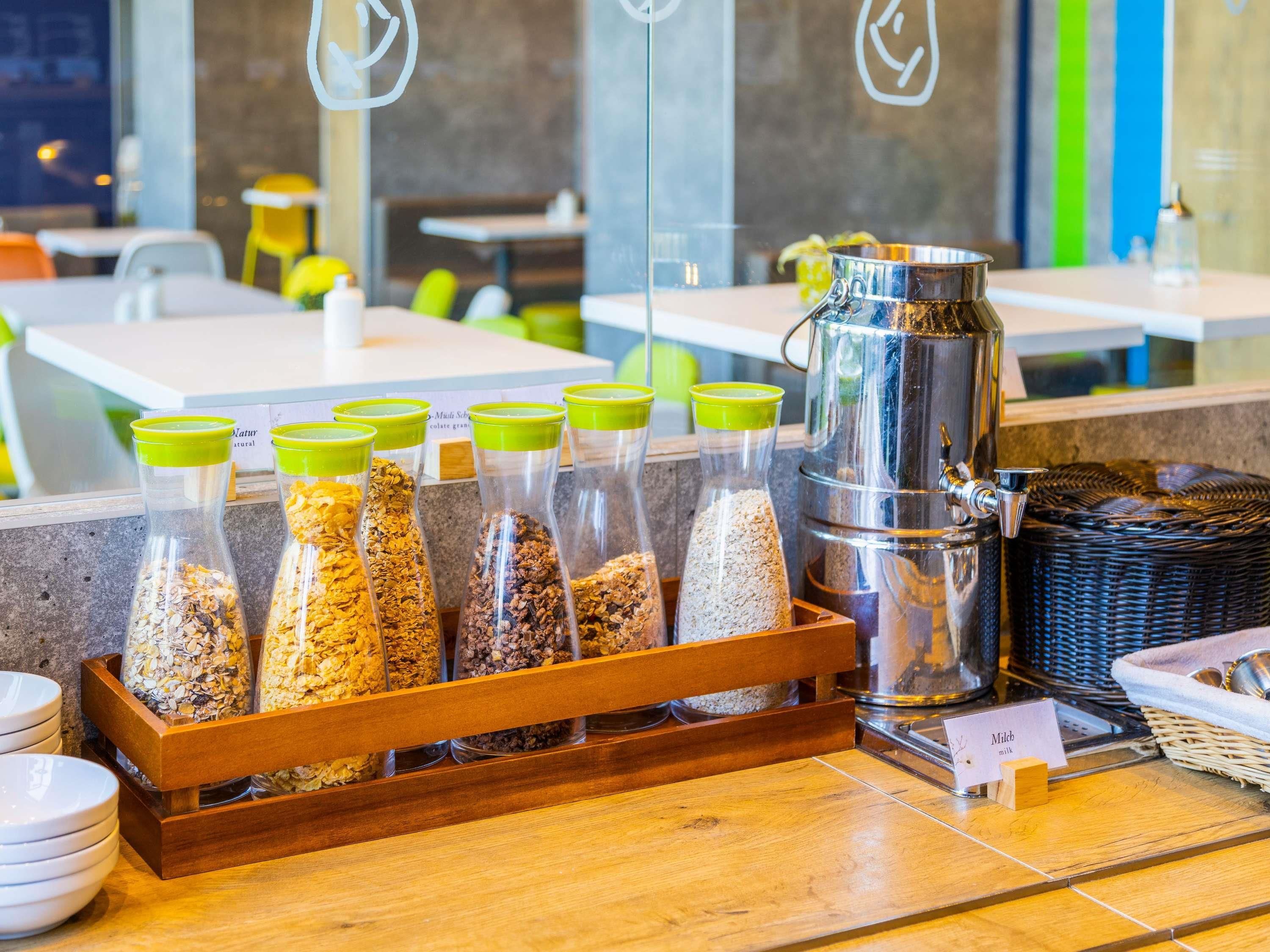 Un bar pour le petit-déjeuner avec des bocaux de granola et un distributeur de lait.