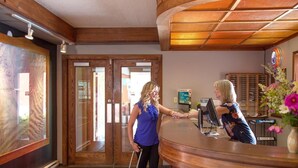 A reception area with a wooden reception desk, a computer, and a sign reading "The Province". - The Lodge at Arrow Lakes (Nakusp)