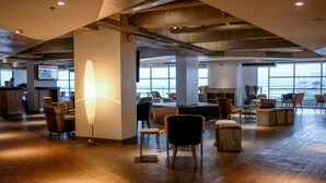 A spacious lobby with wooden flooring, modern furniture, and large windows offering views of the city. - TRYP by Wyndham Mall of Asia Manila (Pasay)