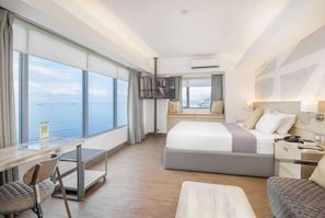 A modern hotel room with a large window, a bed, a desk, and a chair. - TRYP by Wyndham Mall of Asia Manila (Pasay)