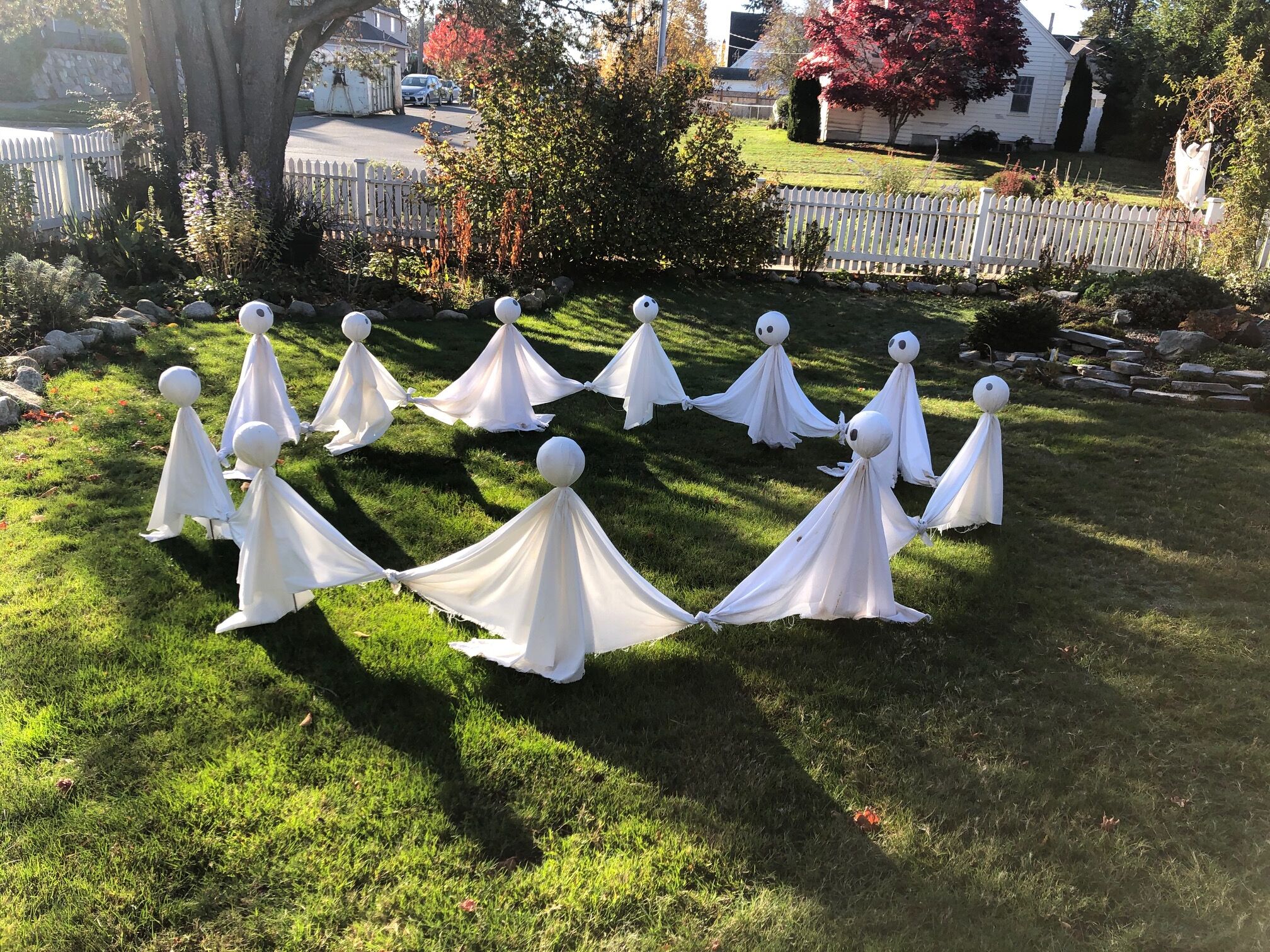 Un césped con siluetas blancas que evocan fantasmas dispuestas en círculo.