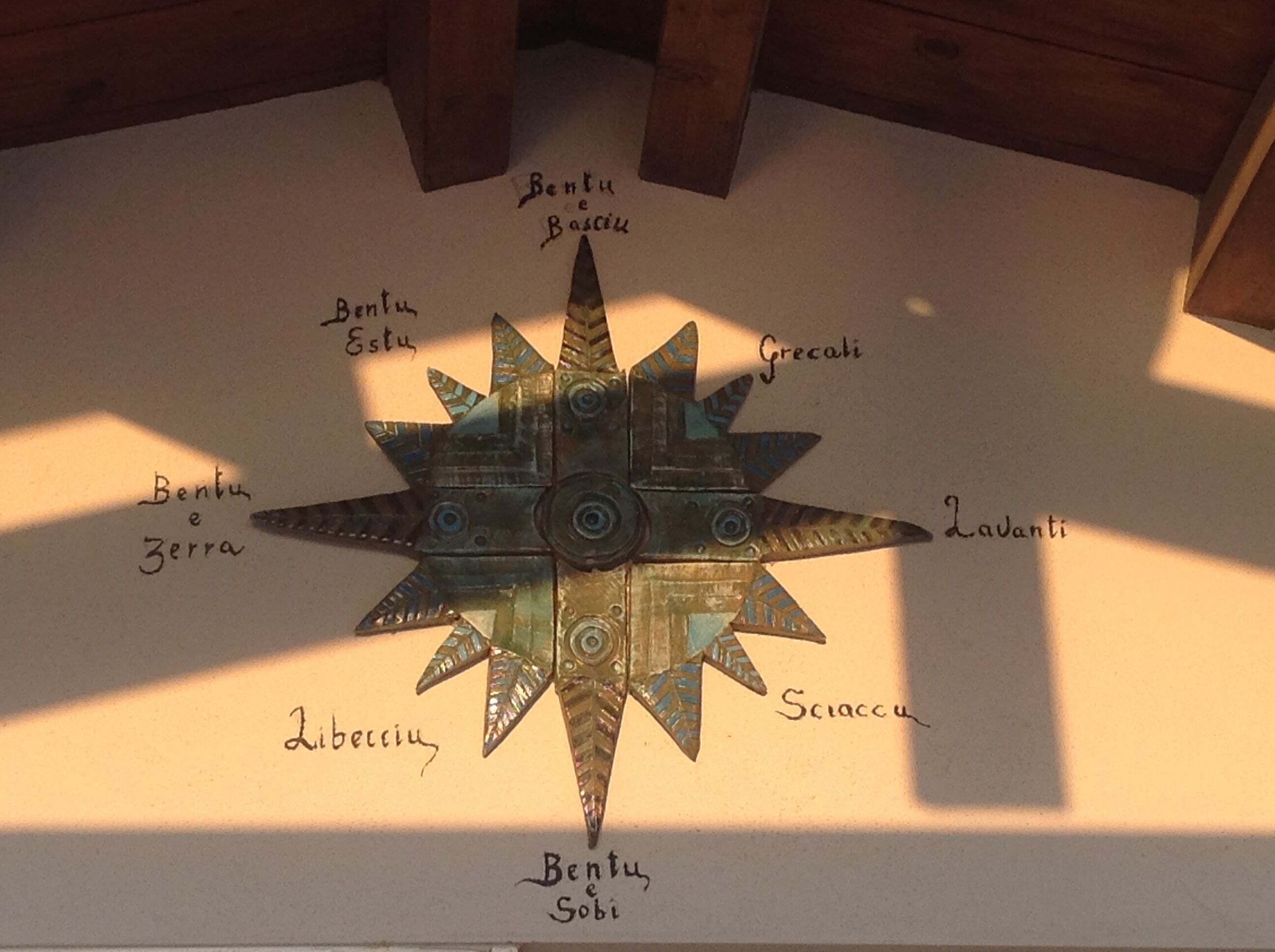 Eine sternförmige Metallskulptur mit Inschriften auf dem Boden.