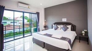 A modern hotel room with a large bed, a nightstand, a lamp, and a view of the outside. - The Bed Hotel (Phitsanulok)