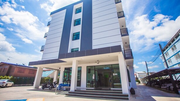 A modern building with a flat roof, large windows, and a covered entrance area. - The Bed Hotel (Phitsanulok)