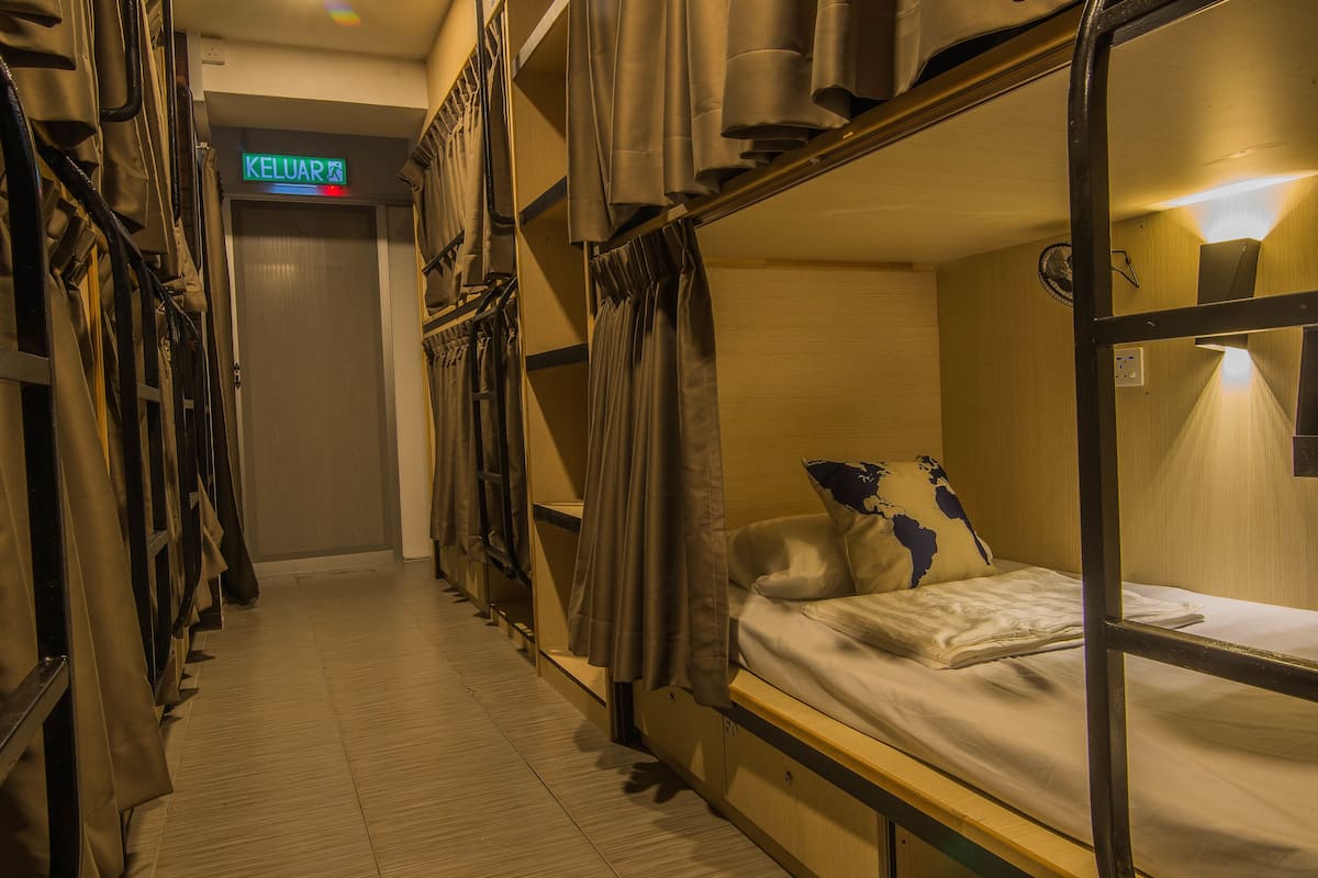 A corridor with bunk beds, a sign indicating 'KELUAR', and a door at the end.