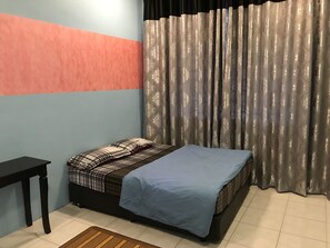 Un dormitorio con cama, mesita de noche y ventana con cortinas.