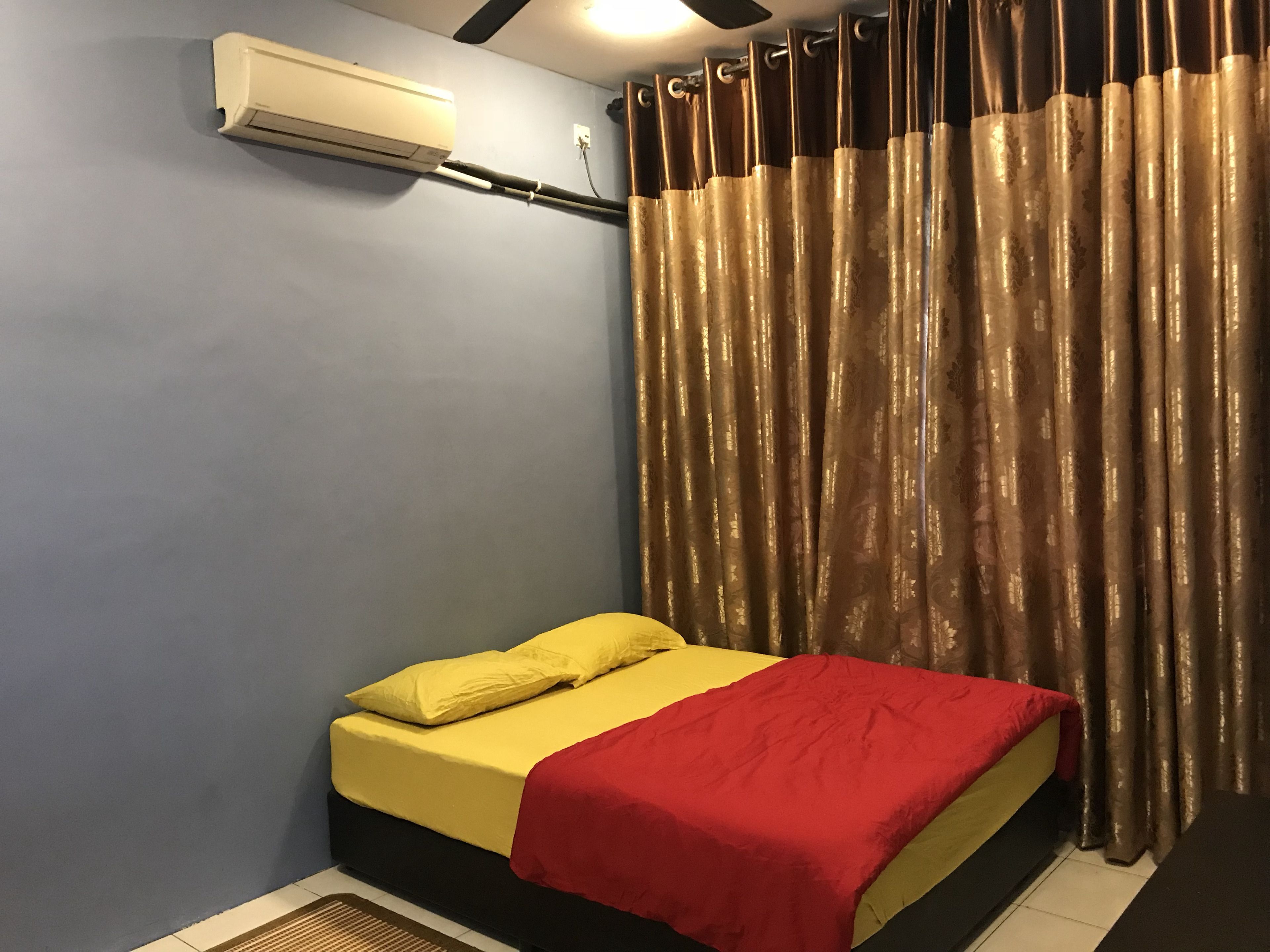 Una habitación con cama, ventilador de techo y ventana con cortinas.