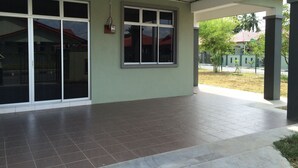A covered outdoor area with a tiled floor, large windows, and a visible electrical box on the wall. - Aushaf Homestay Changlun (Changlun)