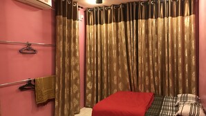 A bedroom with a bed, a ceiling fan, a window with curtains, and an air conditioning unit. - Aushaf Homestay Changlun (Changlun)