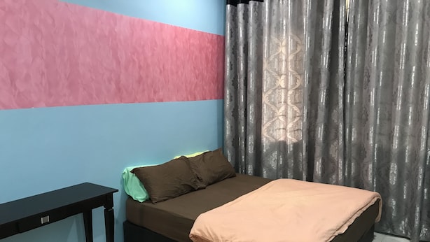 Une chambre à coucher avec un lit, une table de chevet et une fenêtre avec des rideaux.