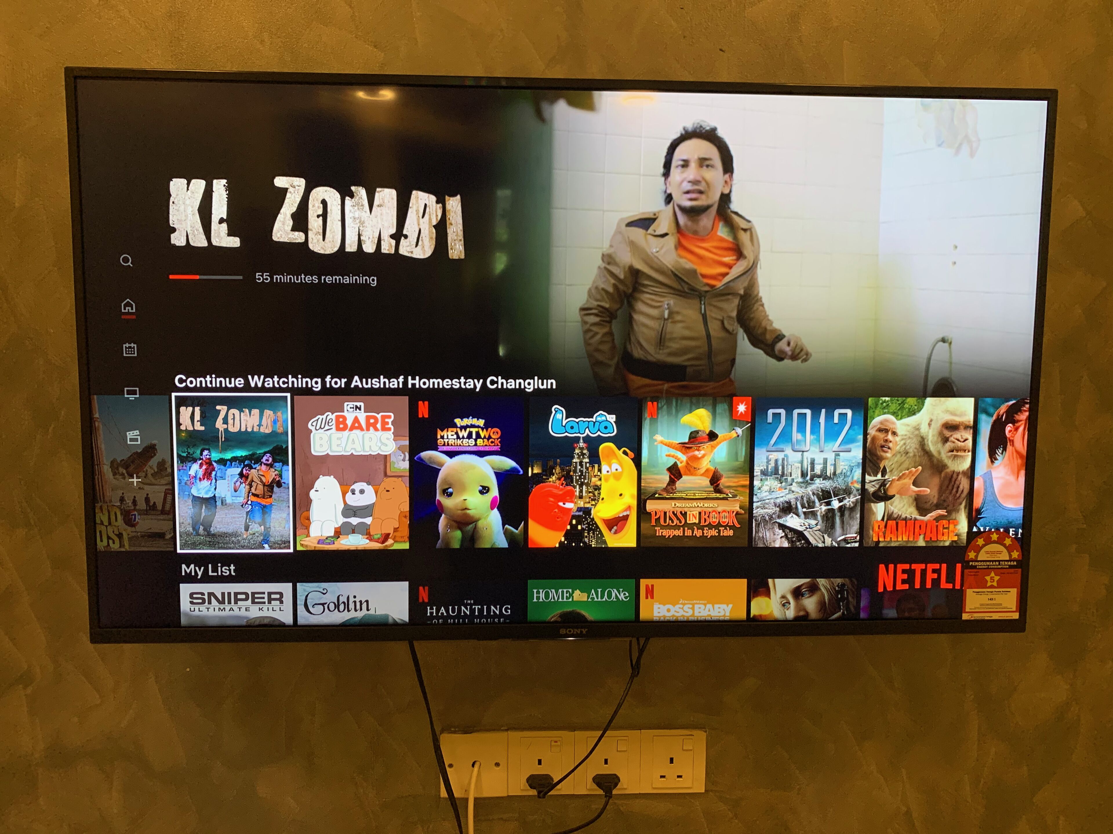 A television displaying a movie selection menu with titles like 'XL Zombies' and 'We Bare Bears'.