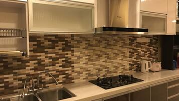 A modern kitchen with a stainless steel sink, a gas stove, and a microwave.
