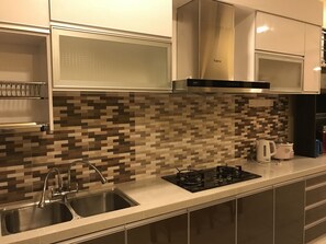 Una cocina moderna con un lavamanos de acero inoxidable, una estufa a gas y un microondas.
