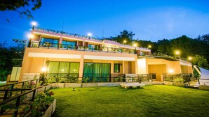 A two-story building with a flat roof, large windows, and a balcony on the upper floor. - Hotel on Hilltop (Kathu)