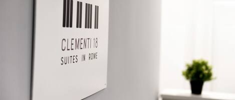 A sign with a barcode and text reading "Clementi 18 Suites in Rome".
