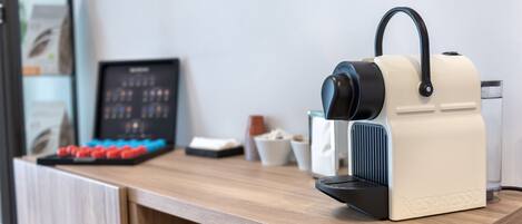 Una encimera de cocina con una cafetera, una balanza digital y un cuadro enmarcado.