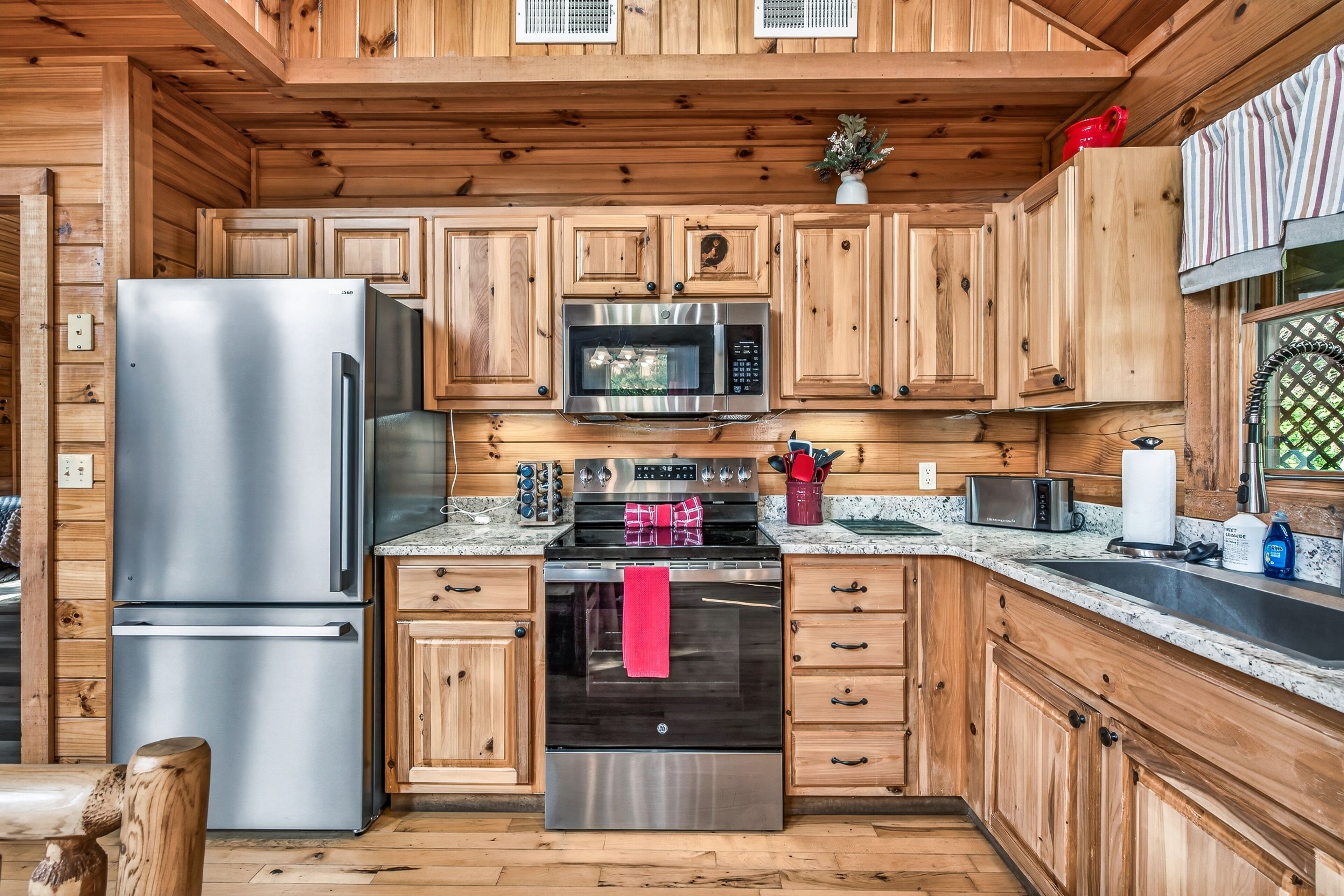 A modern kitchen with wooden cabinets, stainless steel appliances, and a granite countertop.