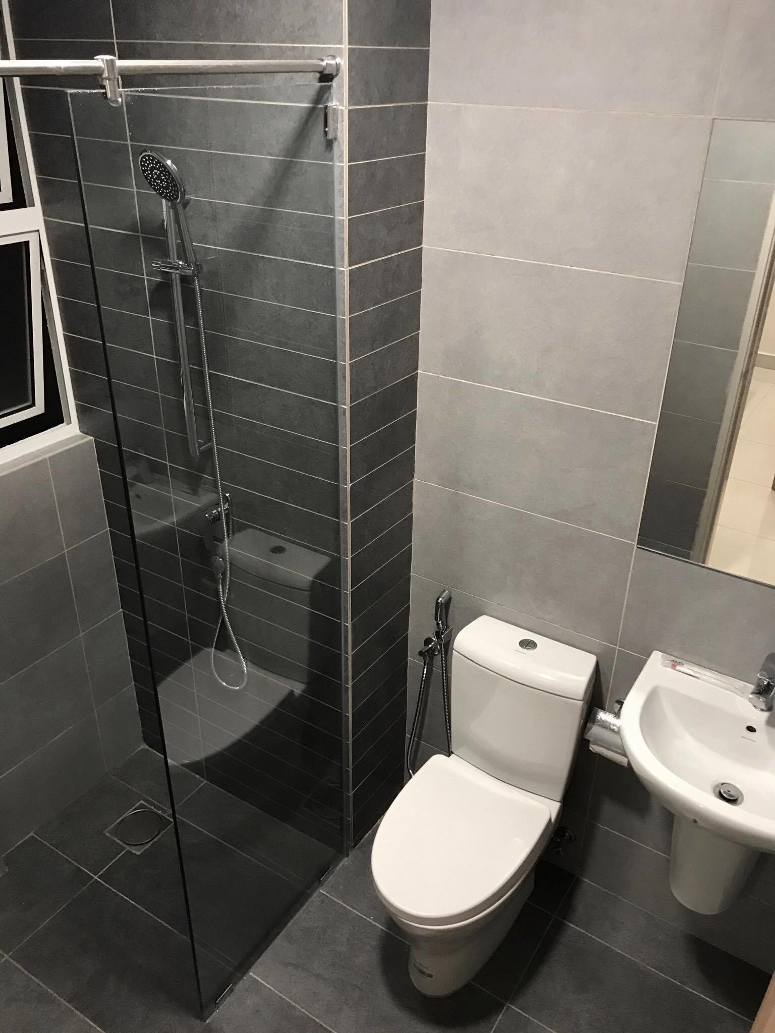A modern bathroom with a glass-enclosed shower, a toilet, and a sink.