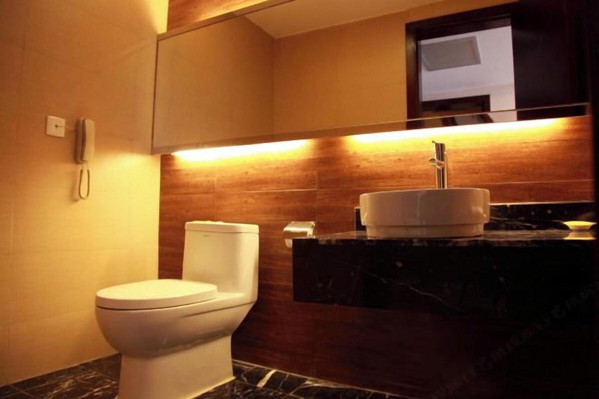 Un baño moderno con inodoro, lavamanos y espejo.