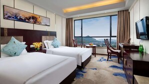 A hotel room with two beds, a desk, a TV, and a large window with a view. - Ramada by Wyndham Liuzhou Luzhai (Suzhou)