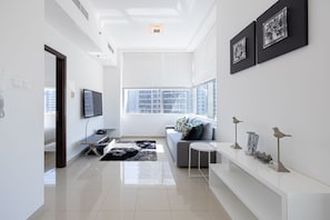 Appartement Deluxe, 1 grand lit, non-fumeurs, vue partielle sur l'océan | Coin séjour | Télévision, Netflix, services de streaming