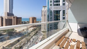 A balcony with a view of a cityscape and the sea. - DHH - Botanica Tower (Dubai)